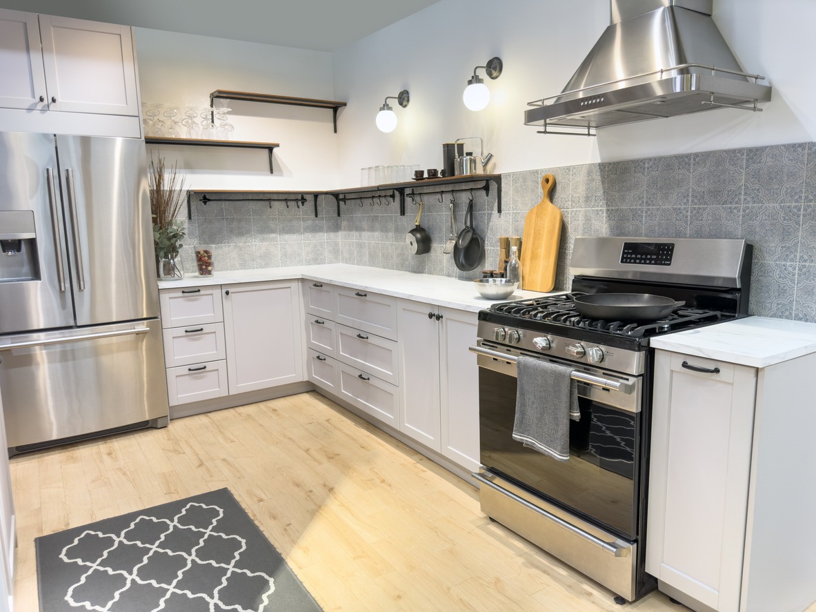 Modern kitchen with cabinets and stainless range and stainless exhaust vent above range